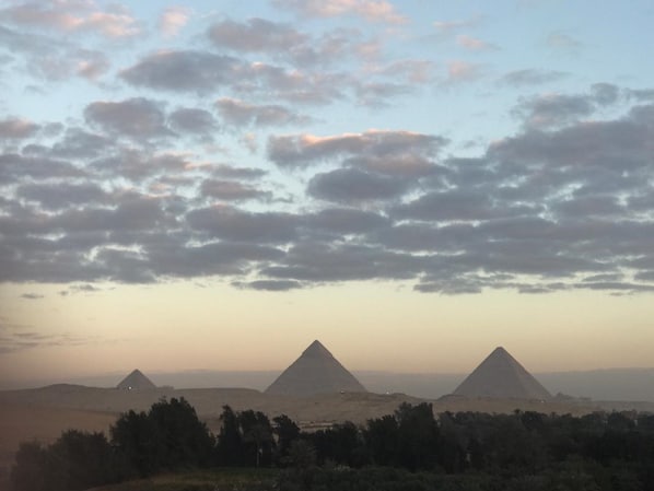 A landscape with three pyramids and a clear sky. - Heru Pyramids View Hotel (Giza)