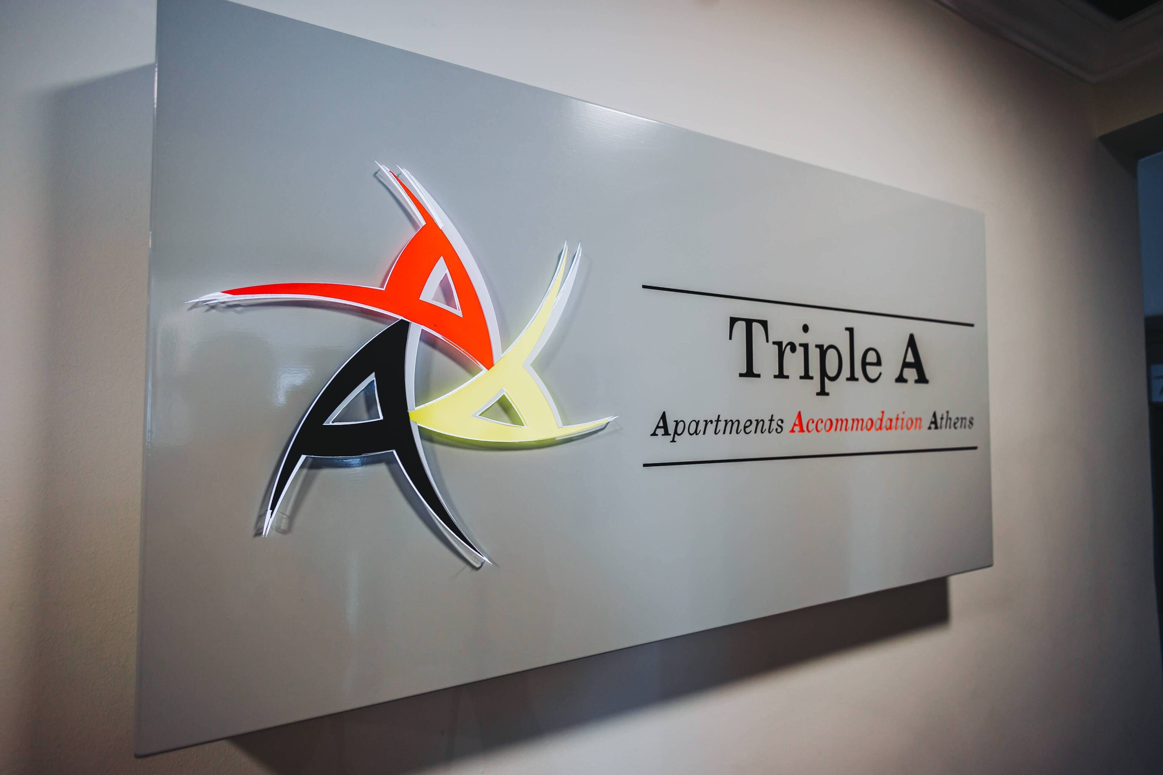 A sign for Triple A Apartments Accommodation Athens with a stylized logo.