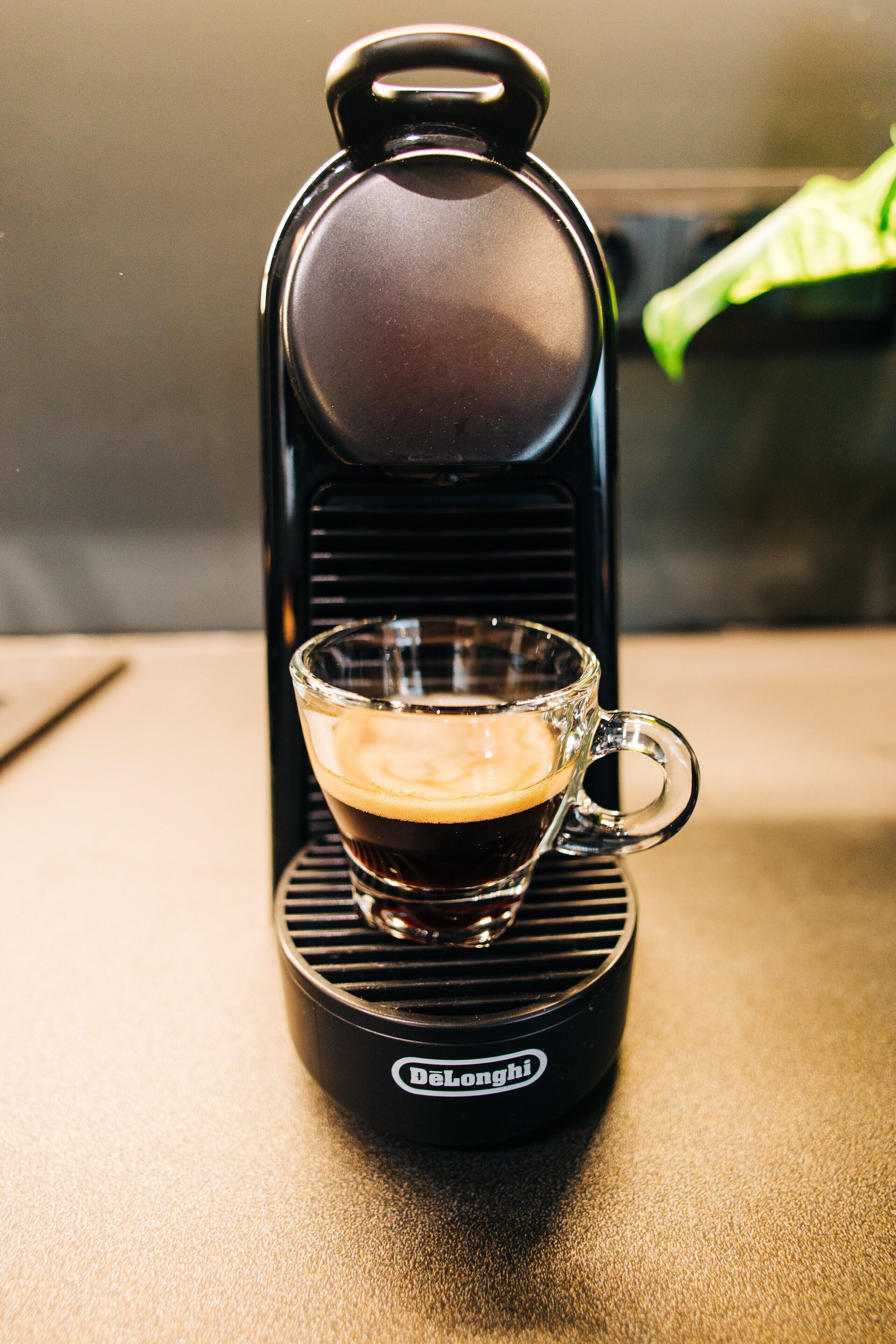 A coffee maker with a glass cup on its base.