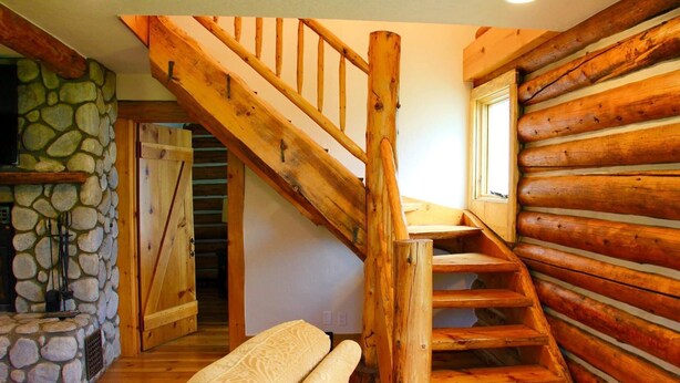 Eine Holztreppe mit einer Steinwand und einer Bank.