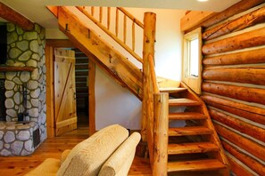 Una escalera de madera con un muro de piedra y un banco.