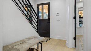 A modern interior with a staircase, a bench, and a door leading outside. - 1st In Line: Mtn. Modern Home, Hot Tub & High End (Telluride)