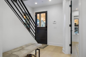 A modern interior with a staircase, a bench, and a door leading outside. - 1st In Line: Mtn. Modern Home, Hot Tub & High End (Telluride)