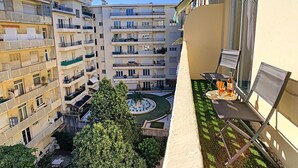 Une cour avec une piscine, entourée d’immeubles à plusieurs étages dotés de balcons.