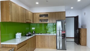Eine moderne Küche mit Holzausstattung, einem Edelstahlkühlschrank und einer grünen Spritzschutzwand.