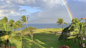 Een golfbaan met uitzicht op de oceaan en een regenboog.