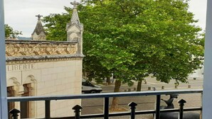 Vista de un edificio con la inscripción "LIBERTE" y un gran árbol en primer plano.