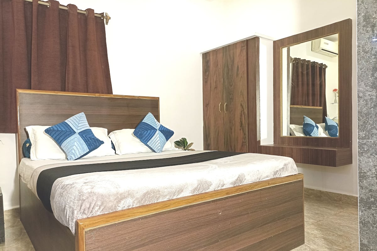 Un dormitorio con una cama de madera, una mesita de noche, un espejo y un armario.