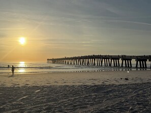 A pier extending into the ocean with people walking along it.