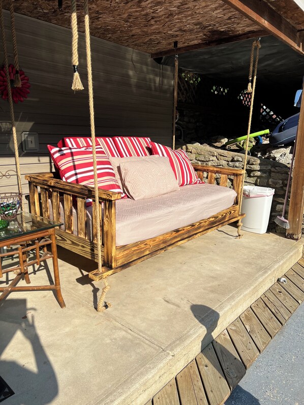 A wicker sofa with striped cushions on a concrete deck. - The French Riviera 2000 sq ft 2+ bedroom Private Pool (Aurora)