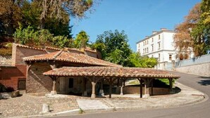 A traditional building with a tiled roof and a covered patio area. - STUDIO LE NID ★ PLEIN CENTER ★ LUMINEUX ★ WIFI (Valence d'Agen)