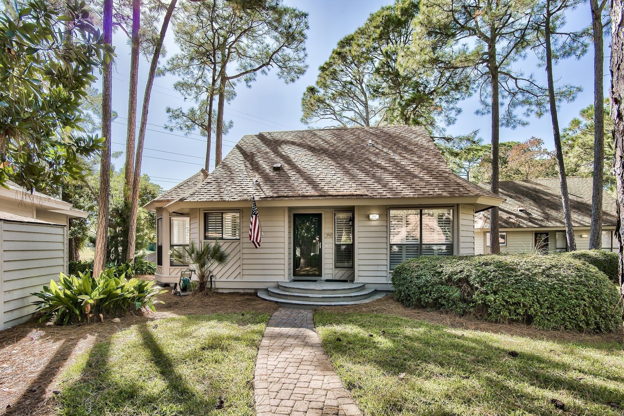 A single-story house with a front porch, a small front yard, and a brick pathway leading to the door.