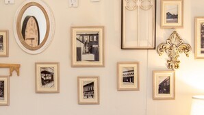 A wall with framed photographs, a mirror, a decorative window, and a "WELCOME" sign. - Cheerful 2 Bedroom Cottage on 5th in Decatur IN (Decatur)