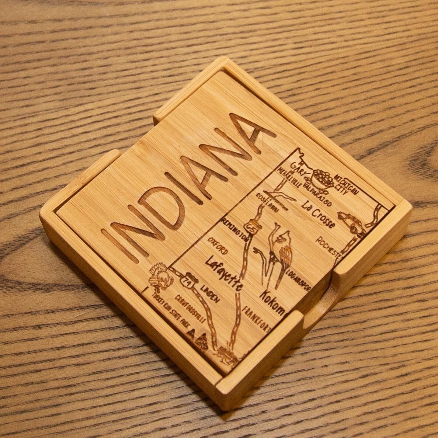 A wooden box with the word "INDIANA" carved on it, placed on a wooden surface.
