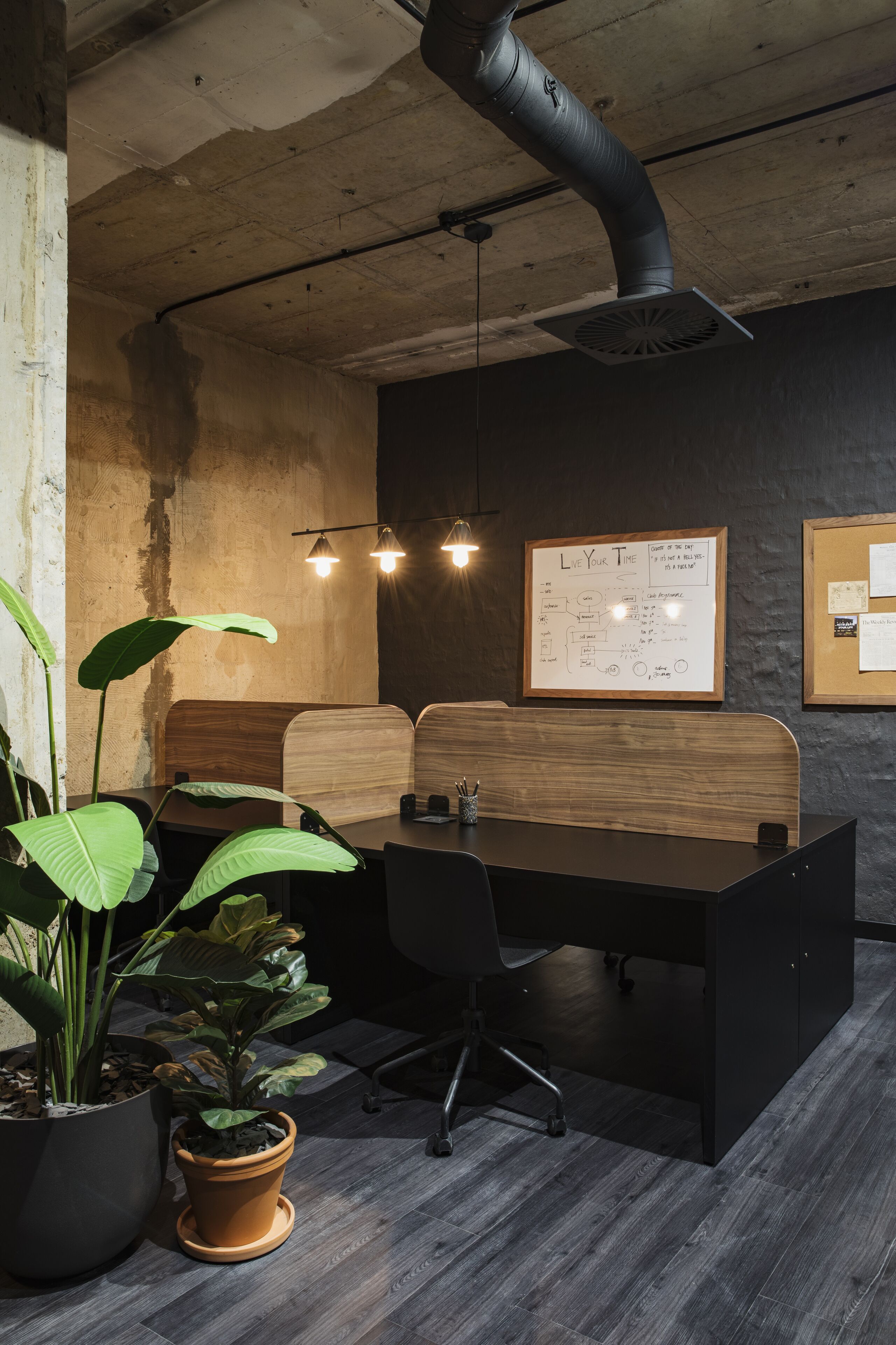 A conference room with a long table, chairs, potted plants, and a whiteboard with diagrams.