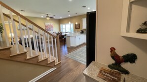 A modern kitchen with white cabinets, a wooden island, and a welcome sign. - The Barndominium at Berkeley Ridge - Book your getaway today! (BERKELEY SPRINGS)