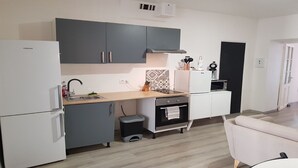 A compact kitchen with grey cabinets, a built-in oven, a microwave, and a sink. - GET ★ QUIET ★ WIFI TERRACE (Revel)