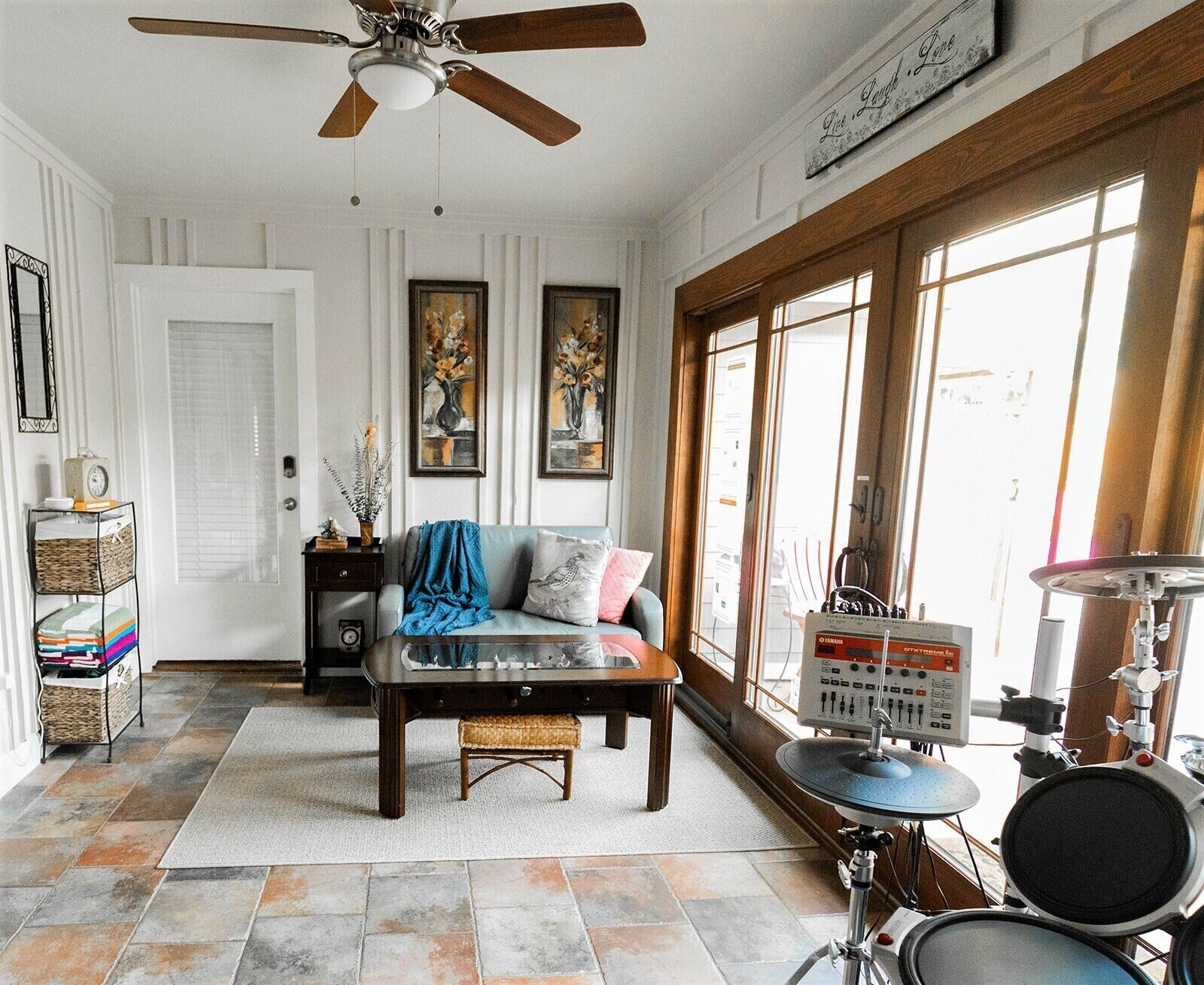 A living room with a sofa, coffee table, and a drum set.