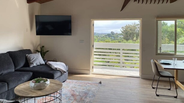 A modern living room with a dark grey sofa, a wooden coffee table, and a large fish decoration on the wall.