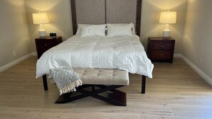 A bedroom with a large bed, two bedside tables with lamps, and a bench at the foot of the bed. - Gorgeous Contemporary Palm Desert Home.  Ask about March - April discount!! (Palm Desert)