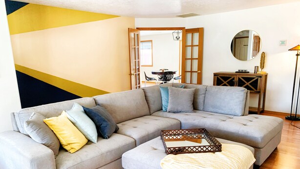 A living room with a sectional sofa, a small table, and a floor lamp. - Peaceful Ranch-style Single level 3B Retreat (Hillsboro)