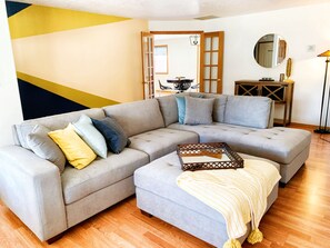 A living room with a sectional sofa, a small table, and a floor lamp. - Peaceful Ranch-style Single level 3B Retreat (Hillsboro)