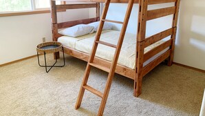 A bunk bed with a ladder, a small round table, and a window in a room with carpeted flooring. - Peaceful Ranch-style Single level 3B Retreat (Hillsboro)