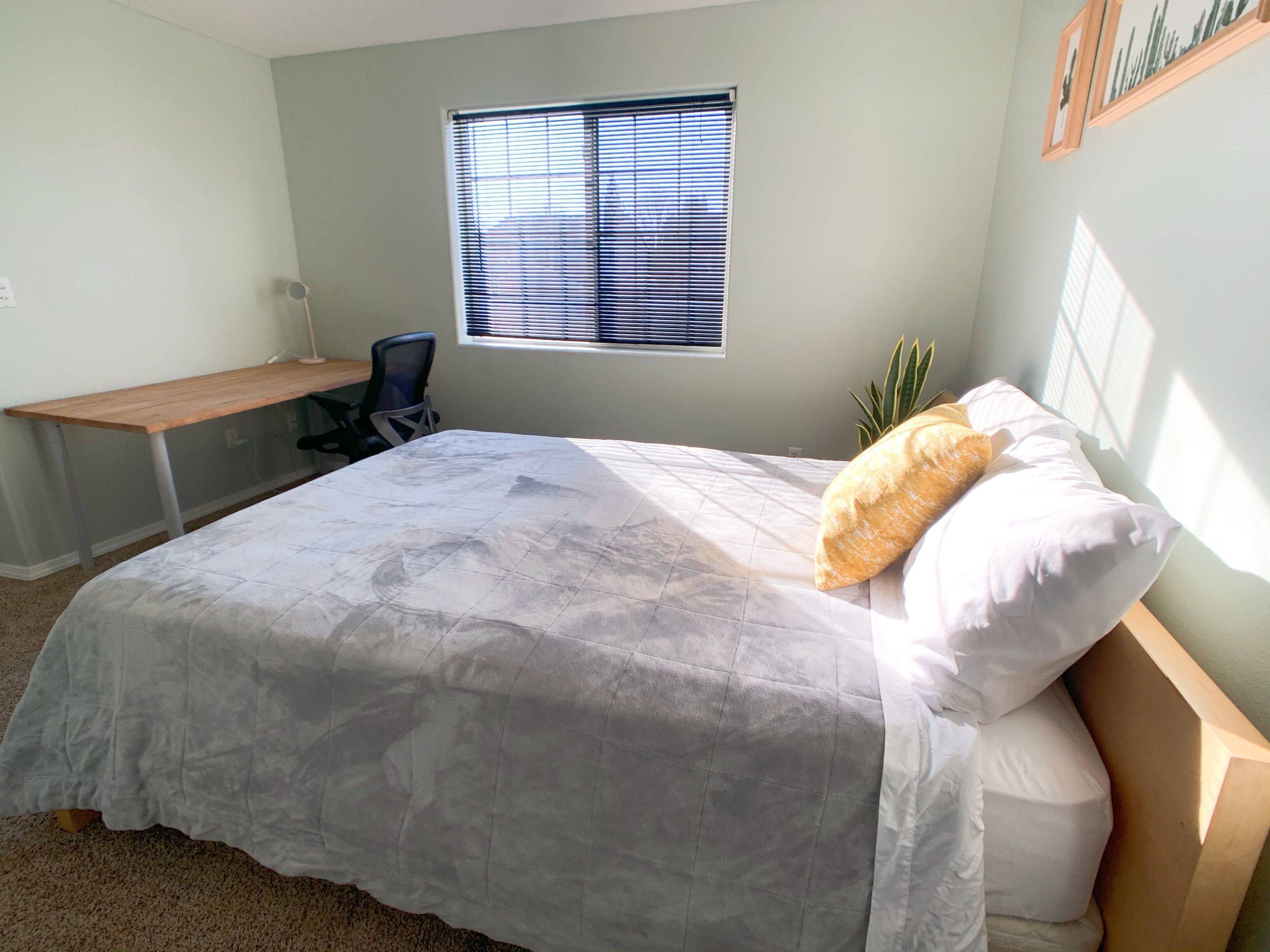 Un dormitorio con cama, escritorio y silla.