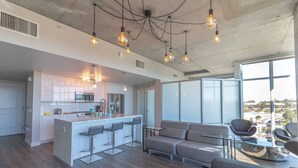 Una cocina moderna con una isla central, taburetes de bar e iluminación colgante.