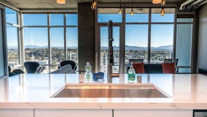 Una cocina moderna con una isla grande, ventanas amplias y vistas a la ciudad.