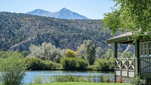 A lakeside view with a mountain in the background, a gazebo, and lush greenery. - Condo on pond w/2 Fishing Badges, 24 Mi. to Aspen! (Carbondale)