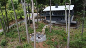 Una cabana de dues plantes amb un porxo cobert i una zona amb llar de foc.