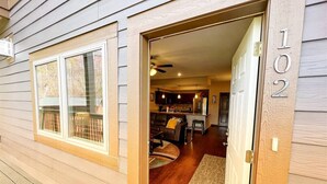 A wooden house with a number '102' on the door, a kitchen, and a living area with a couch and coffee table. - HV 102, great view, Handicapped accessible (Gatlinburg)