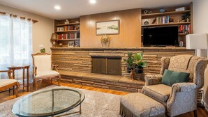 A living room with a fireplace, bookshelves, a television, and a comfortable seating area.
