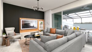 A modern living room with a grey sectional sofa, a white armchair, and a black and white painting on the wall.