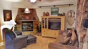 A cozy living room with a fireplace, a television, and comfortable seating.