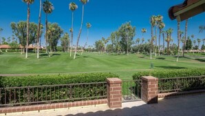 A golf course with a clear view of the green and fairways, surrounded by tall palm trees. - Private 2 Bed 2 .5 Baths Spacious Condo (Palm Desert)