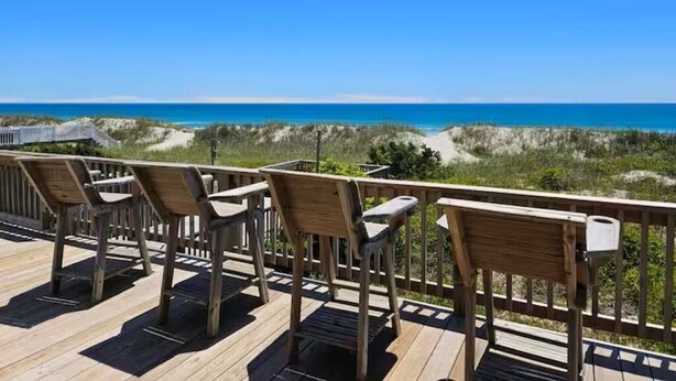 A wooden deck with chairs overlooking a beach. - Toes in the Sand 🏖 Drink in Hand!  2 Decks, Views throughout, Great location! (Emerald Isle)