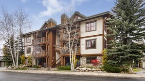 A multi-story house with a stone facade, wooden balconies, and a stone foundation. - Quiet - Spacious- On Ski Bus Line - Community Hot Tubs - WD (Steamboat Springs)