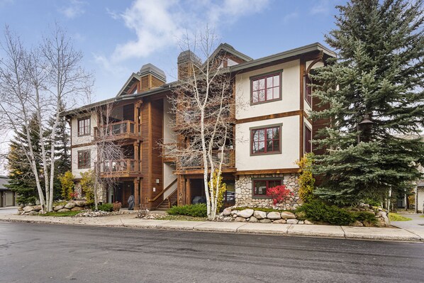 A multi-story house with a stone facade, wooden balconies, and a stone foundation.