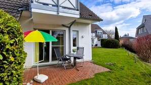 A house with a patio, a table, and a chair.