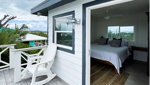 A bedroom with a bed, pillows, and a window. - Honeymoon Suite (Elbow Cay)