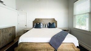 A bedroom with a wooden headboard, white bedding, and a ceiling fan. - Ocean front loft. (Elbow Cay)