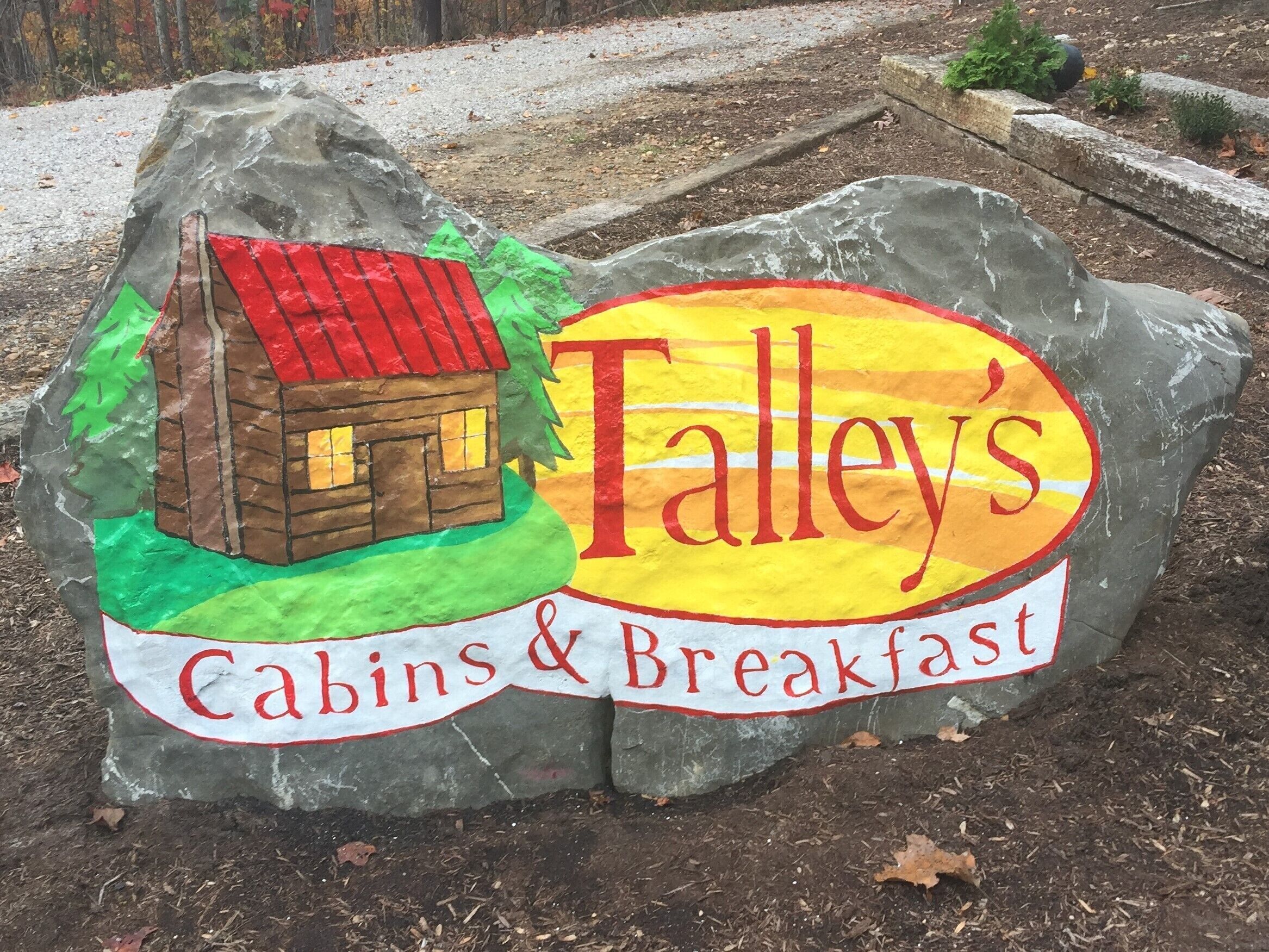 A sign for Talley's Cabins & Breakfast, featuring a cabin illustration and the establishment's name.