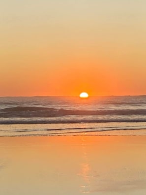 A beach with a sunset over the ocean. - The Bach on Dorset 🌊 (Opunake)