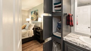 A bedroom with a bed, nightstands, a lamp, and a painting of a beach scene. - Discover Durham, just a quick 11-minutes from Duke University (Durham)