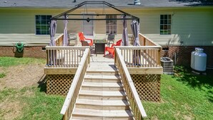 A wooden deck with a railing leading to a covered patio area with outdoor furniture. - Discover Durham, just a quick 11-minutes from Duke University (Durham)