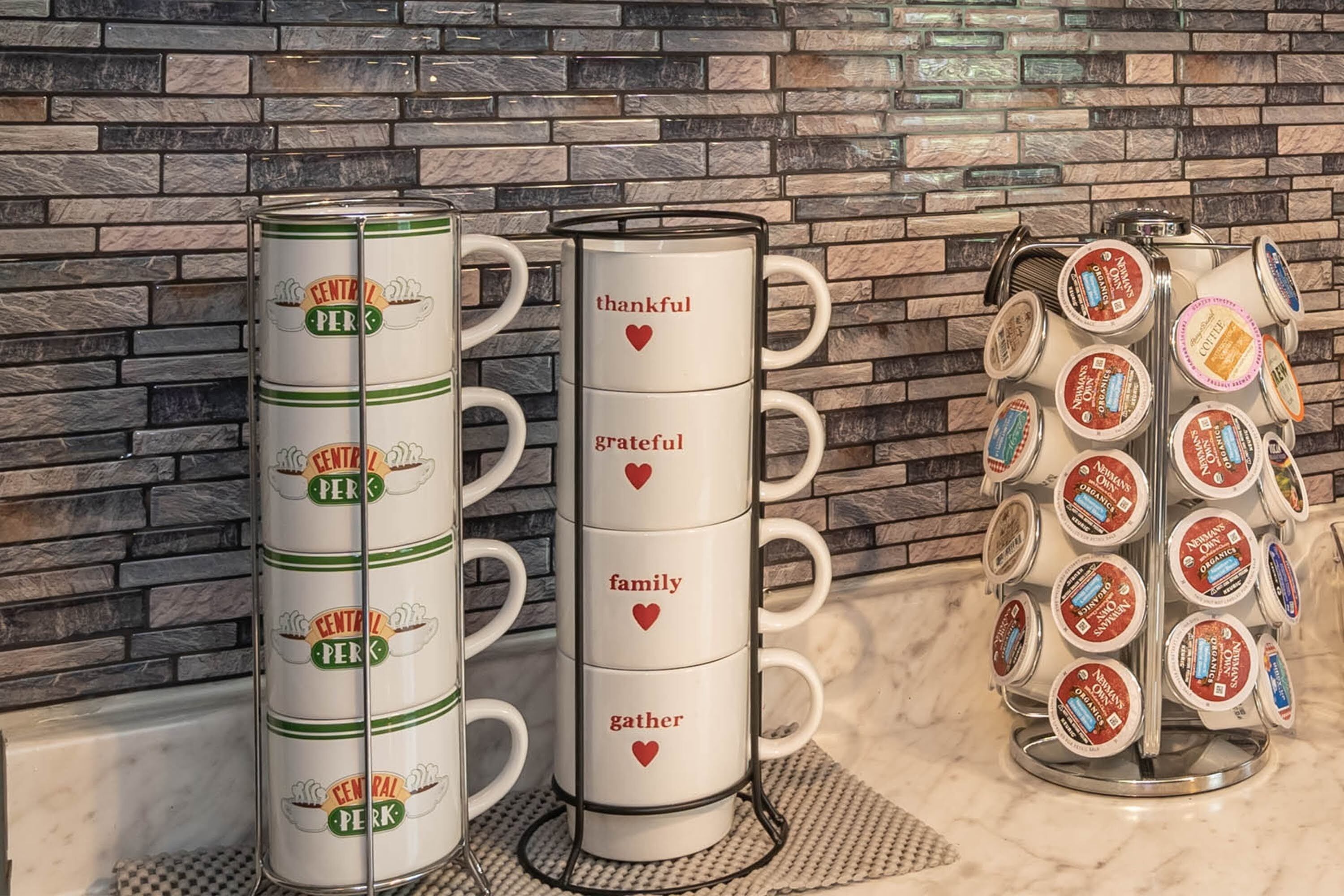 Un comptoir de cuisine aménagé en coin café, avec des tasses à café personnalisées et une machine à café.
