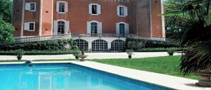A large building with a swimming pool in front.