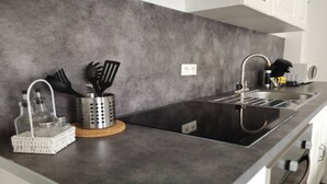 Una cucina moderna con un piano di lavoro nero, lavello in acciaio inossidabile e cappa aspirante.
